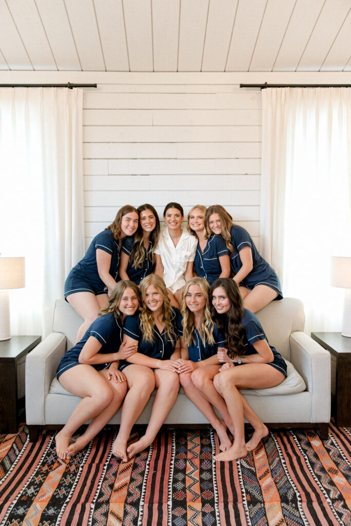 Bridesmaids and bride taking a group photo in the cozy suite at Morgan Creek Barn.