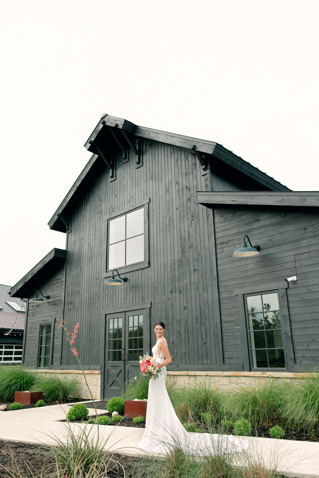 Bride with florals outside of Morgan Creek Barn in Dripping Springs, Texas.