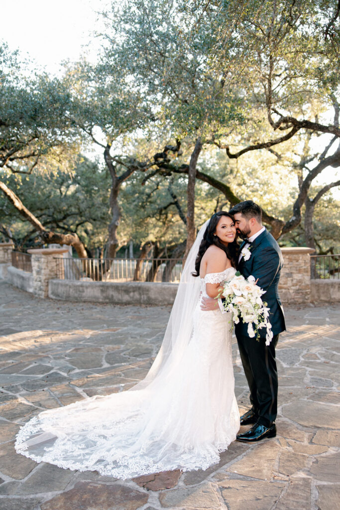 Bride and Groom outside at Lost Mission, a Texas Hill Country venue, with a bridal bouquet.