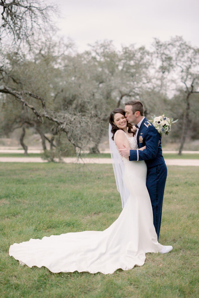 Bride and groom in open field at chapel at gruene 