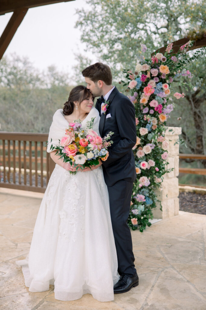 Bride and groom surrounded by spring florals in Boerne by Lois M Photography.