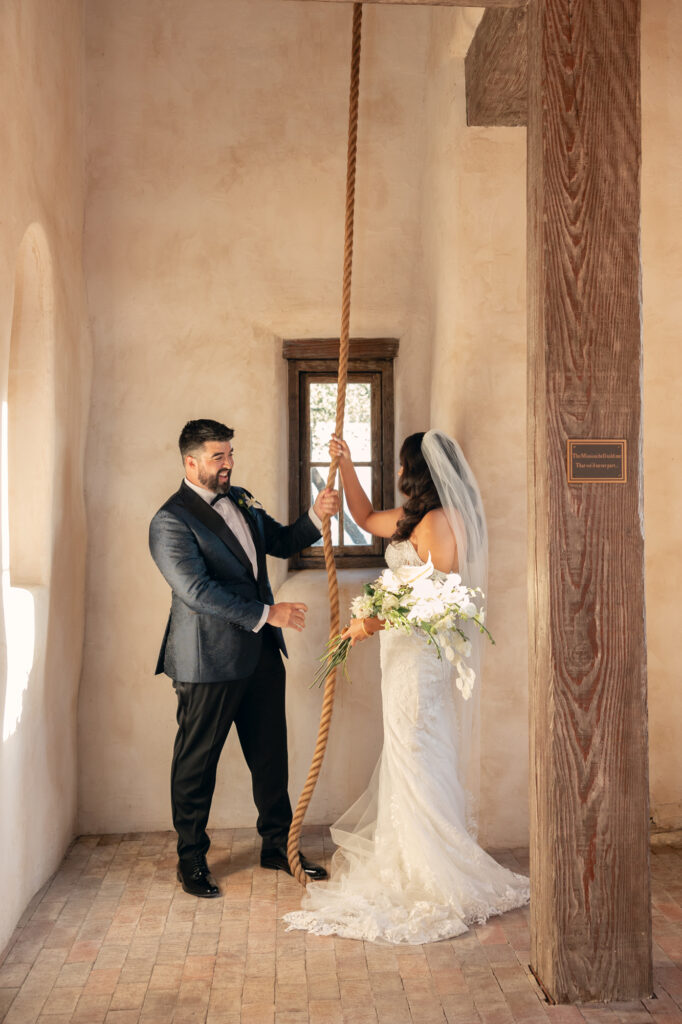 Bride and groom ringing the bell at the end of their wedding ceremony at Lost Mission.