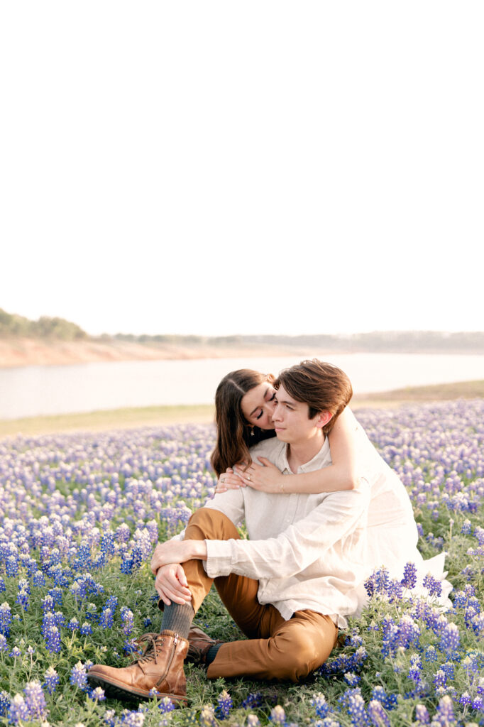 surrounded by bluebonnet flowers sharing a kiss