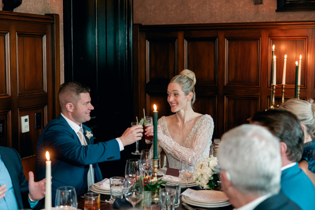 Bride and Groom in Hotel Emma toasting at their table in the Swiggle Key room.
