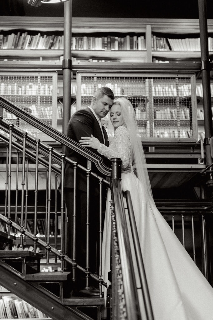 Bride and Groom standing on the stairs in the Library of Hotel Emma.