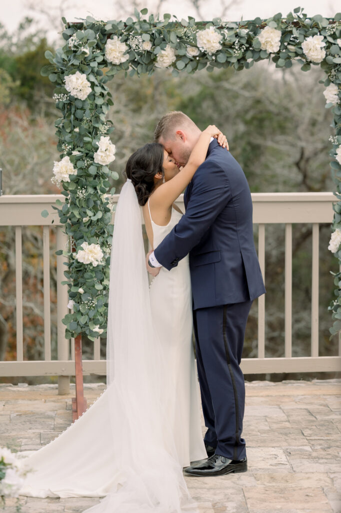 Bride and groom's first kiss at their ceremony at Jacob's Well Vineyard by Lois M Photography.