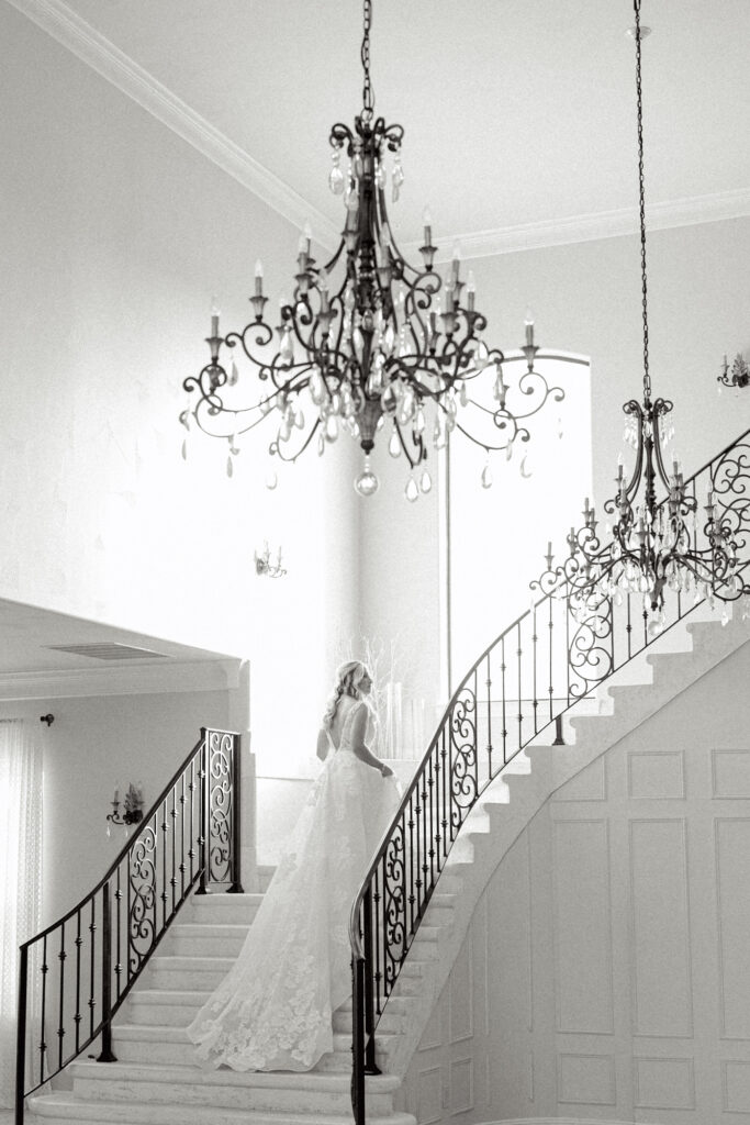 Bride on staircase in the ballroom at Thistlewood Manor in Kyle, Texas by Lois M Photography