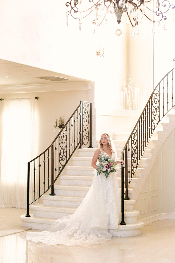 Bride on beautiful staircase in the ballroom of Thistlewood Manor during her bridal session