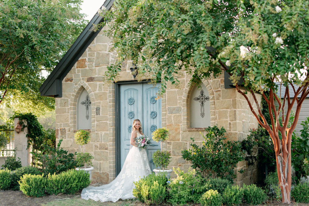 Beautiful bride surrounded by greenery in the courtyard at Thistlewood Manor in Kyle, Texas 