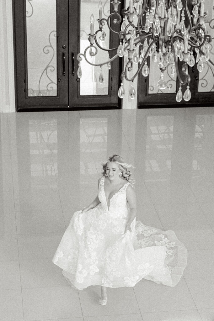 Bride during her bridal session running in the ballroom for a creative photo at Thistlewood Manor and Gardens