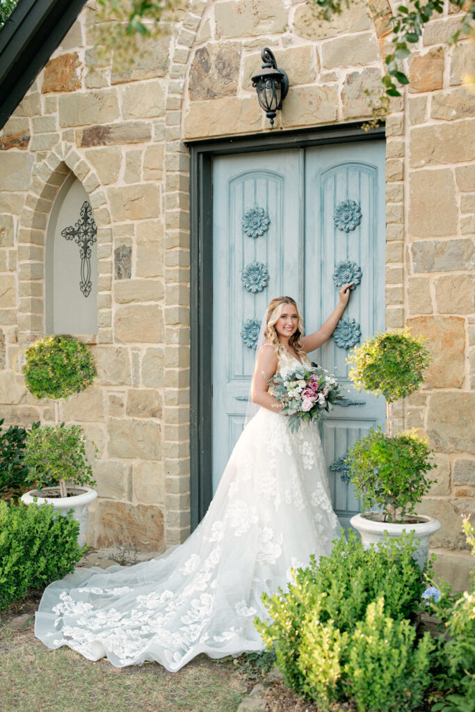 Bride in the Courtyard by blue door at Thistlewood Manor and Gardens