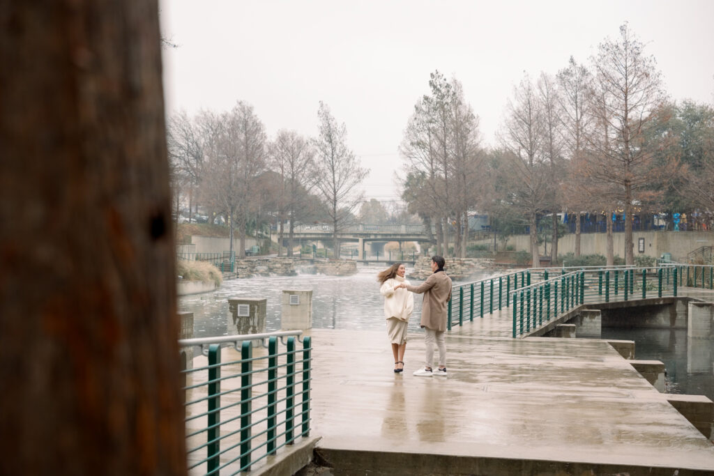 Couple romantically twirling and dancing in the rain at the Pearl Amphitheater
