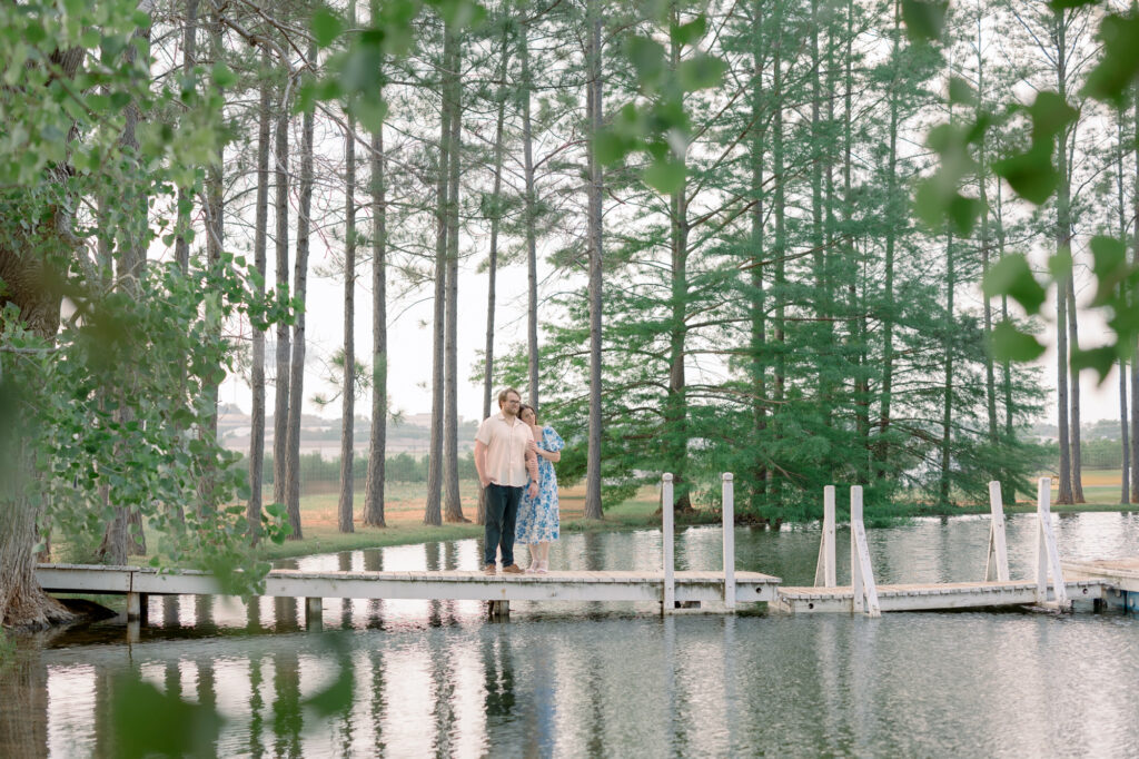 Couple standing on dock surrounded by water and tall trees at Das Peach Haus by Lois M Photography 