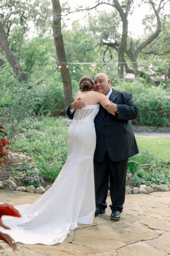 Bride hugging her dad after first look in the front of the Estate House at the Veranda 