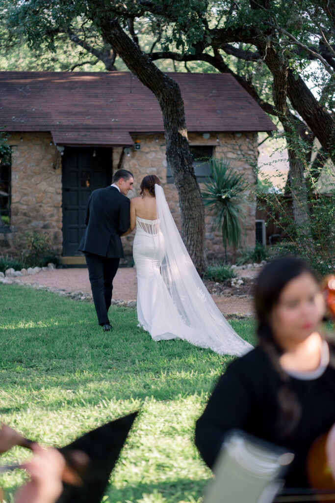 Back of bride and groom walking together to the cottage at the Veranda after their ceremony exit 