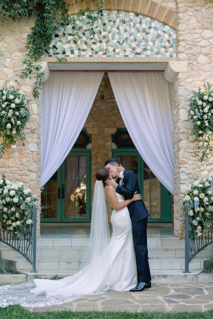 Bride and groom sharing their first kiss at the end of their ceremony on a beautiful sunny day at the Veranda in San Antonio, Texas