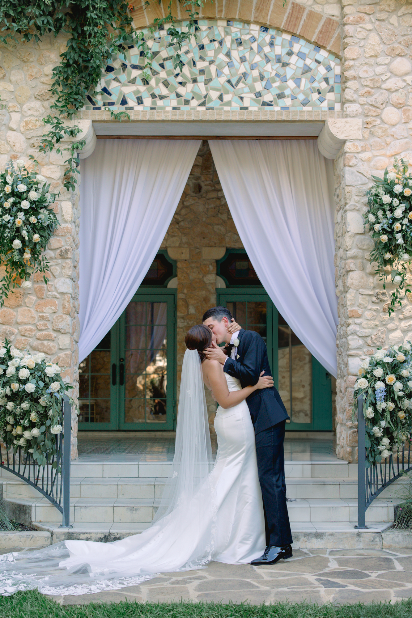 First kiss shared by bride and groom during their wedding ceremony at the Veranda in San Antonio by Lois M Photography