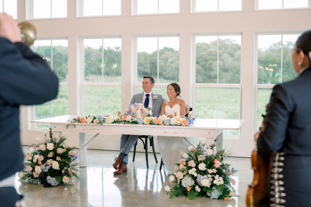 Bride and groom siting at their sweetheart table in the reception hall at Posey Meadows